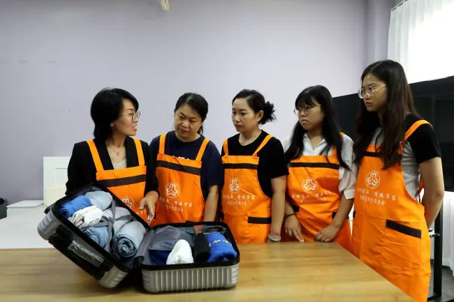 在桥西区沐瑾家政妇女微家，培训讲师向学员讲解旅行箱整理技巧。 张文静摄