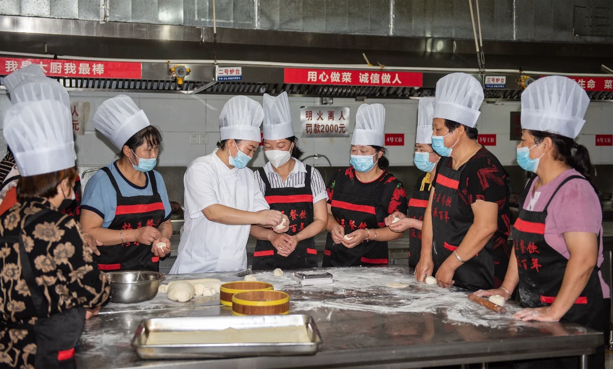 “新徽菜·名徽厨”免费培训班里，学员们正在跟着师傅学习制作面点。吕华摄