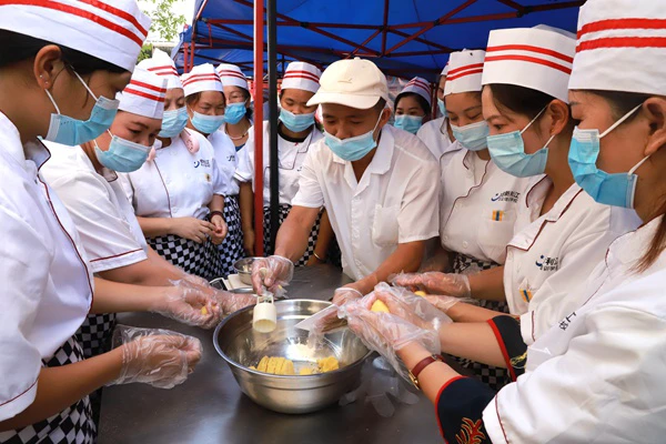 图为授课老师为学员教学绿豆糕的做法